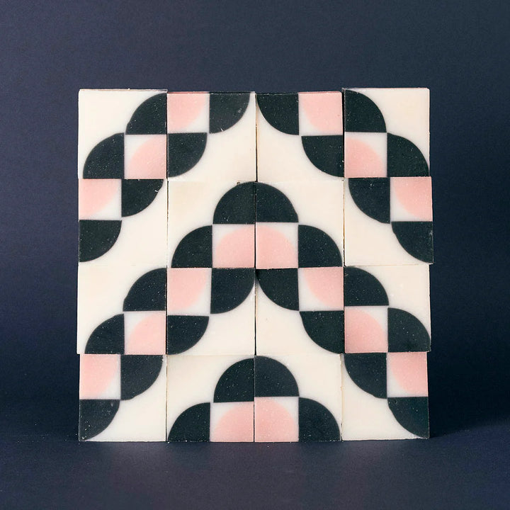 Sixteen organic Ciment Kimono Fleur de Cerisier soaps stacked to form a special tile pattern.