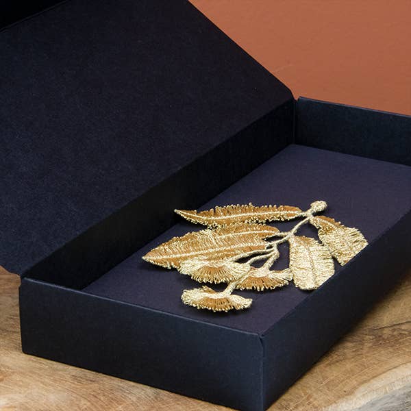Open black gift box containing the Botanopia Eucalyptus flowers embroidery brooch.