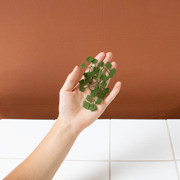 The Botanopia Maidenhair fern embroidery brooch held in a hand.