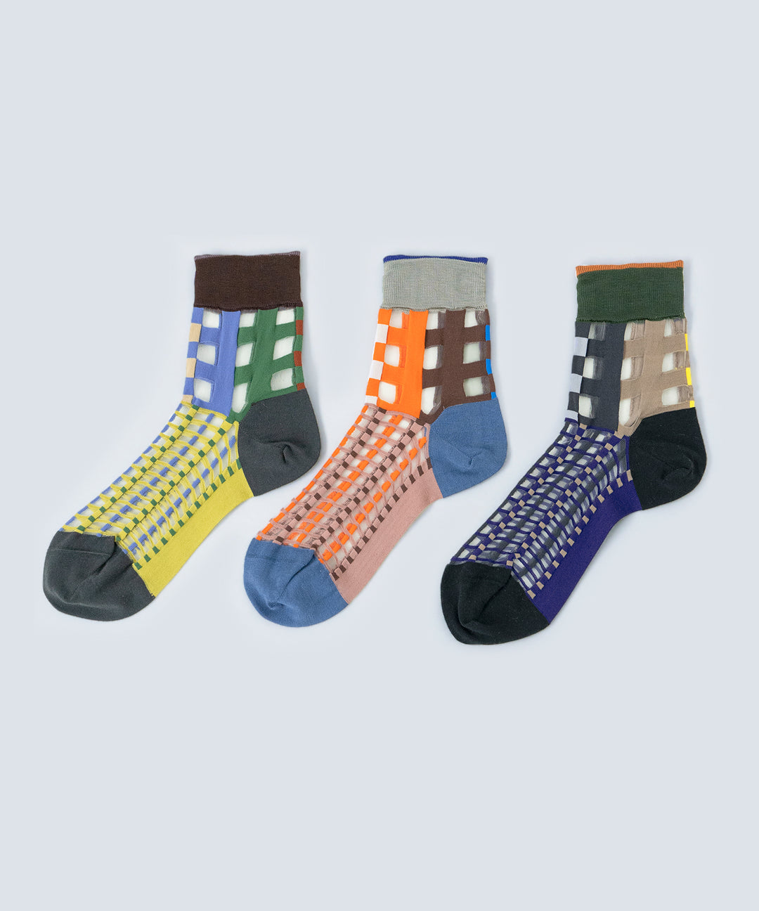 Image showcasing COQ Picnic Window Socks in three colours: orange, navy, and green, made in Japan, highlighting their checked pattern and translucent design.