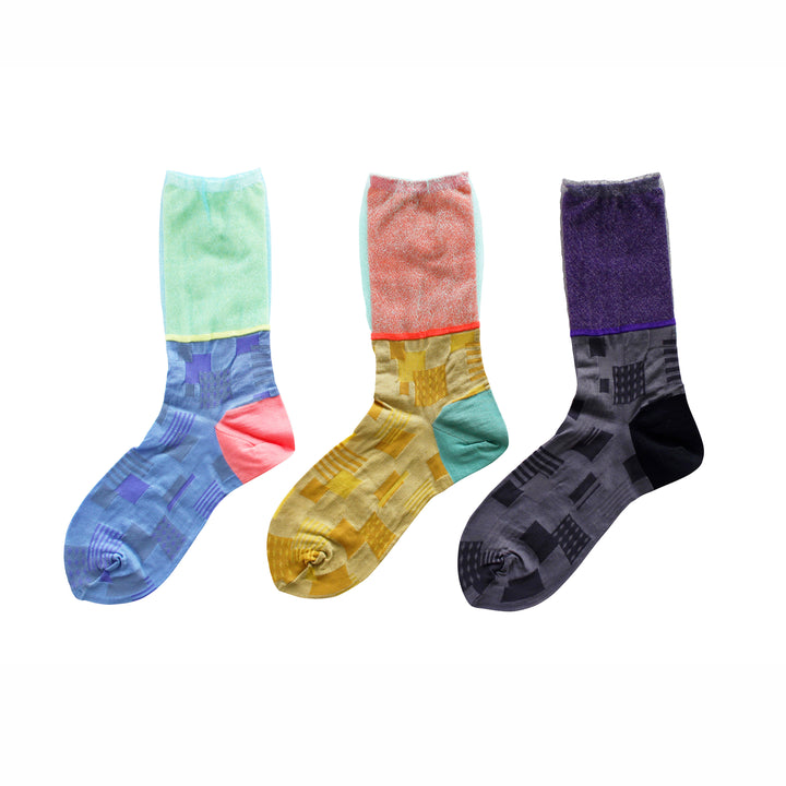 Photo of a set of three COQ Sunlight Block Socks in black, blue, and yellow, displaying their geometric patterns and vibrant colors.