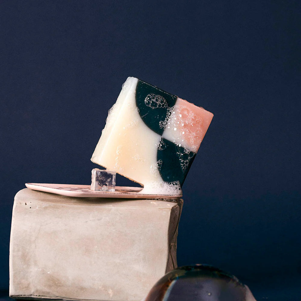 Wet organic Ciment Kimono Fleur de Cerisier soap with bubbles around it.