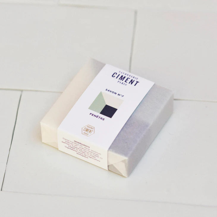 Wrapped organic blue Soap Window Ciment soap placed on white tiles.