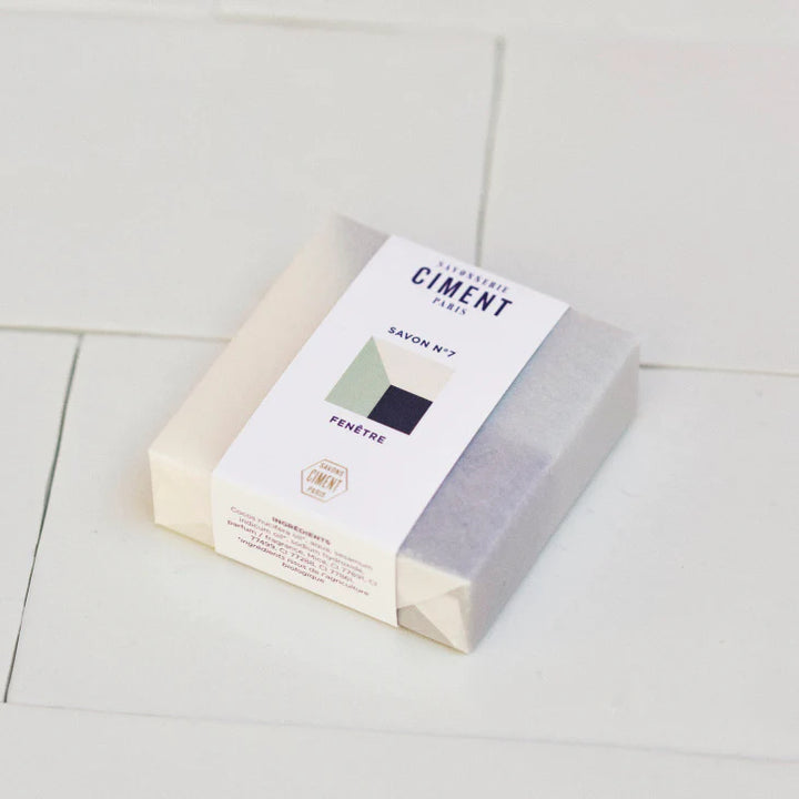 Wrapped organic blue Soap Window Ciment soap placed on white tiles.