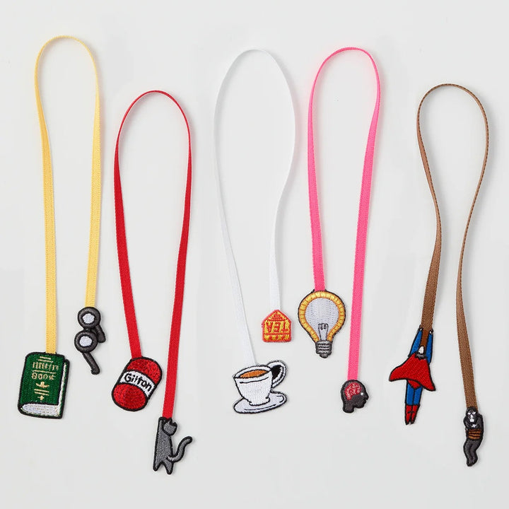 Set of colourful bookmarks with various charms on a white background