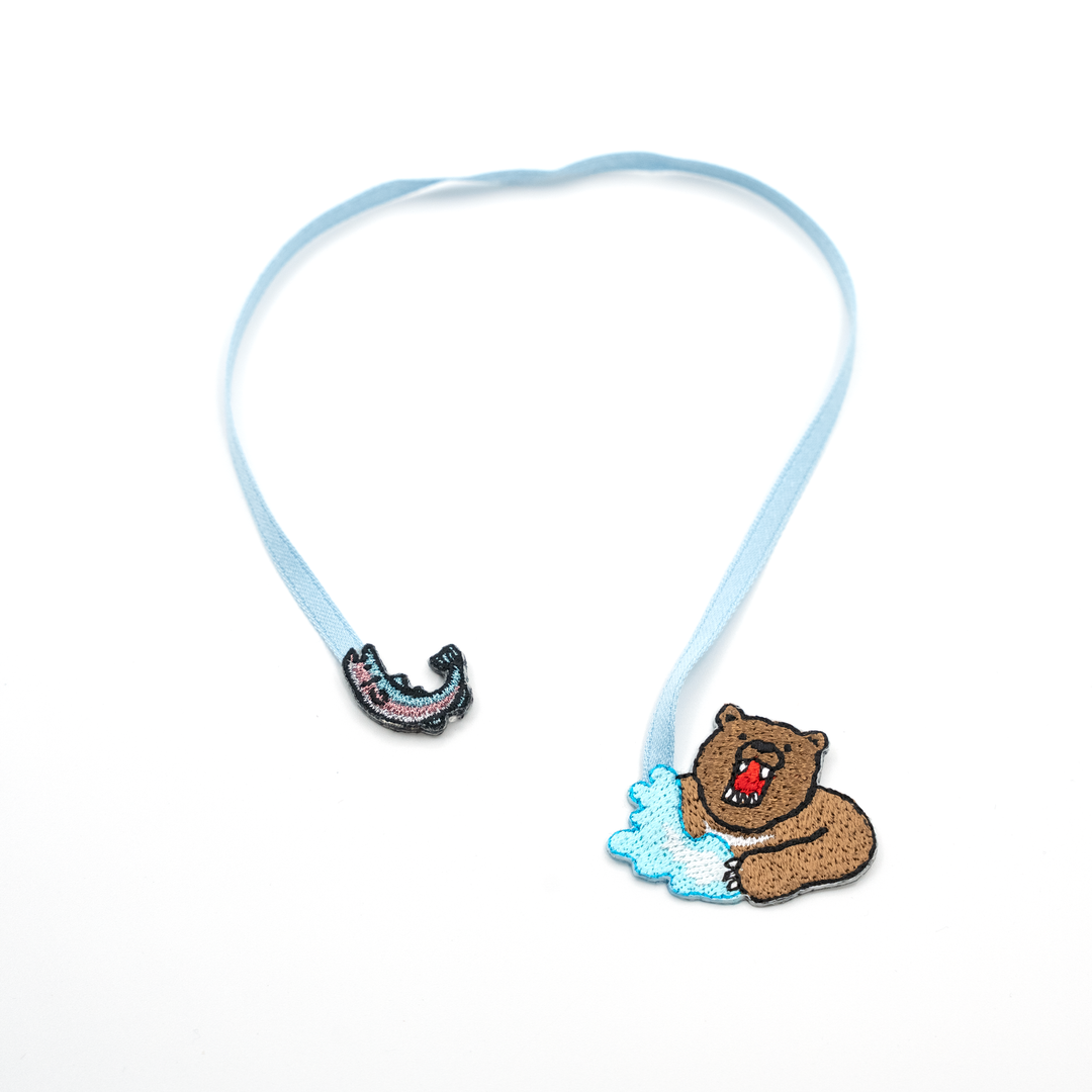 Bookmark with a bear and a fish on a white background