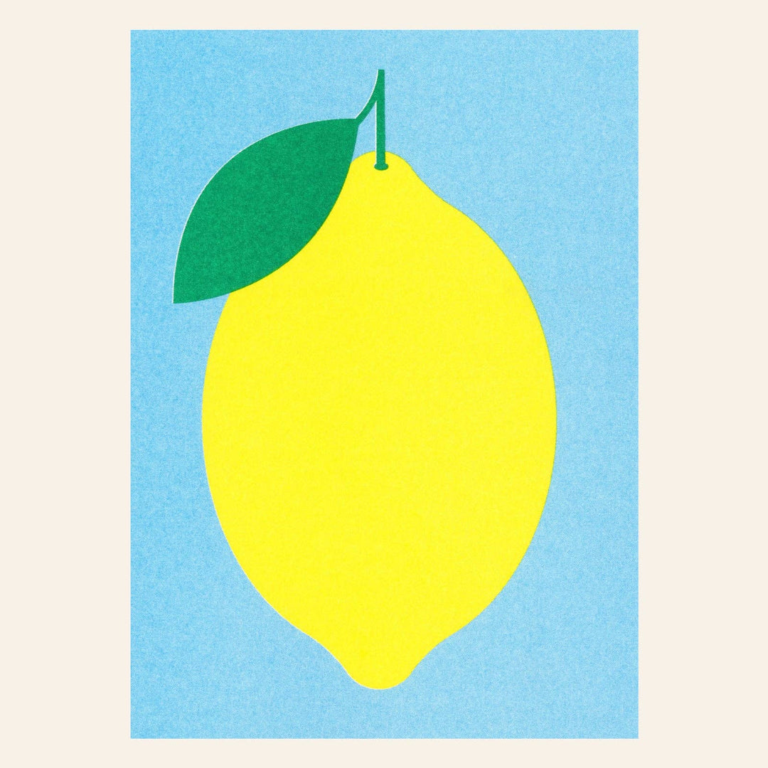 Yellow lemon with a green leaf on a blue background