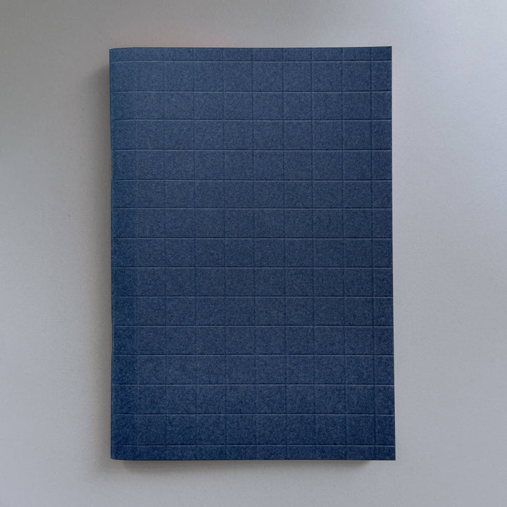 Blue notebook with grid pattern on a white background