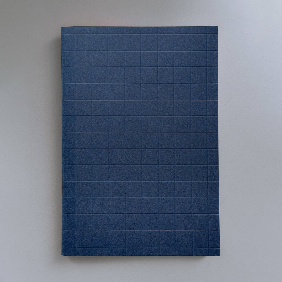Blue notebook with grid pattern on a white background