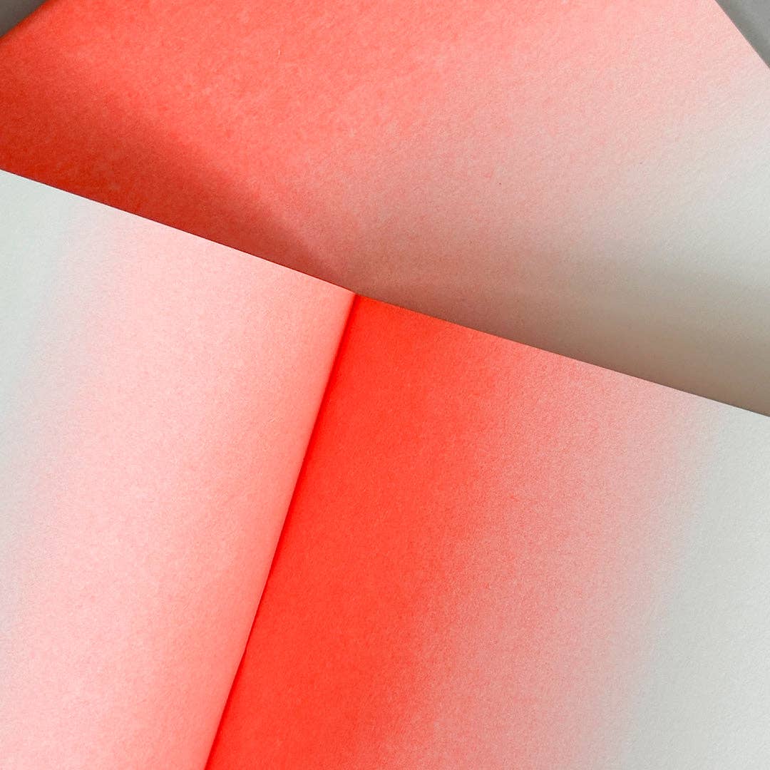 Close-up of red and white risograph paper inside the notebook with a gradient effect