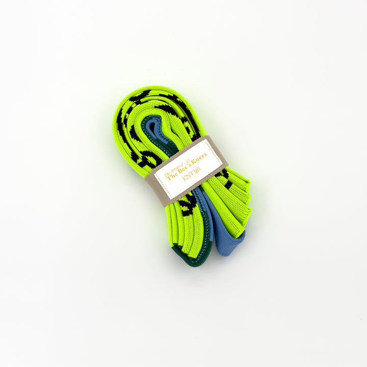 The Craig and Karl Neon Yellow KNT 365 Knitty Tote Bag, folded into a compact size, placed against a white background to highlight its portability and vibrant design.