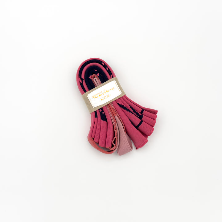 The Craig and Karl Pink KNT 365 Knitty Tote Bag, folded into a compact size, placed against a white background to highlight its portability and vibrant design.