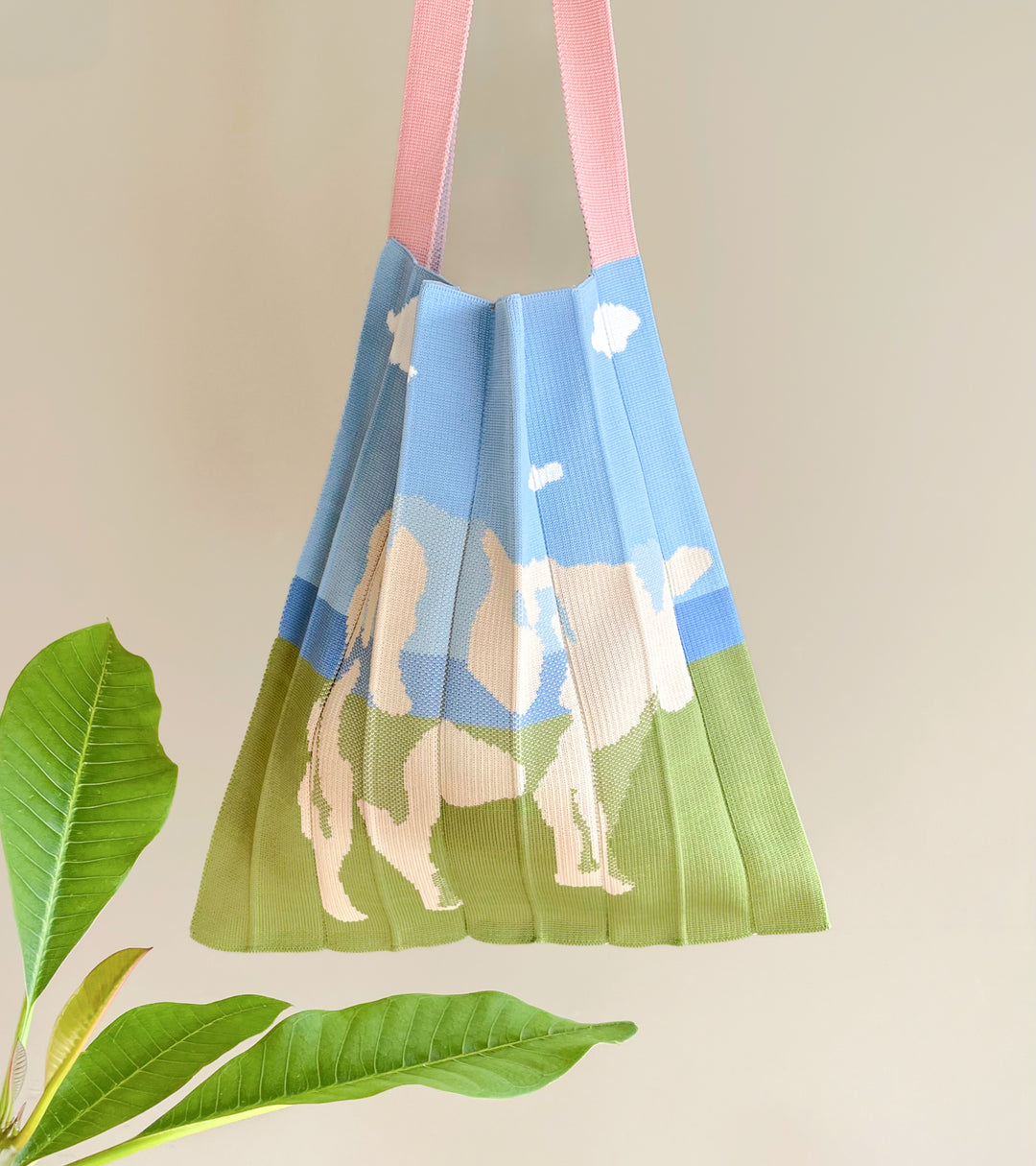 Image of the KNT 365 Knitty Tote Bag featuring a cow illustration, hanging against a wall, showcasing its unique design and craftsmanship, handmade in Japan.