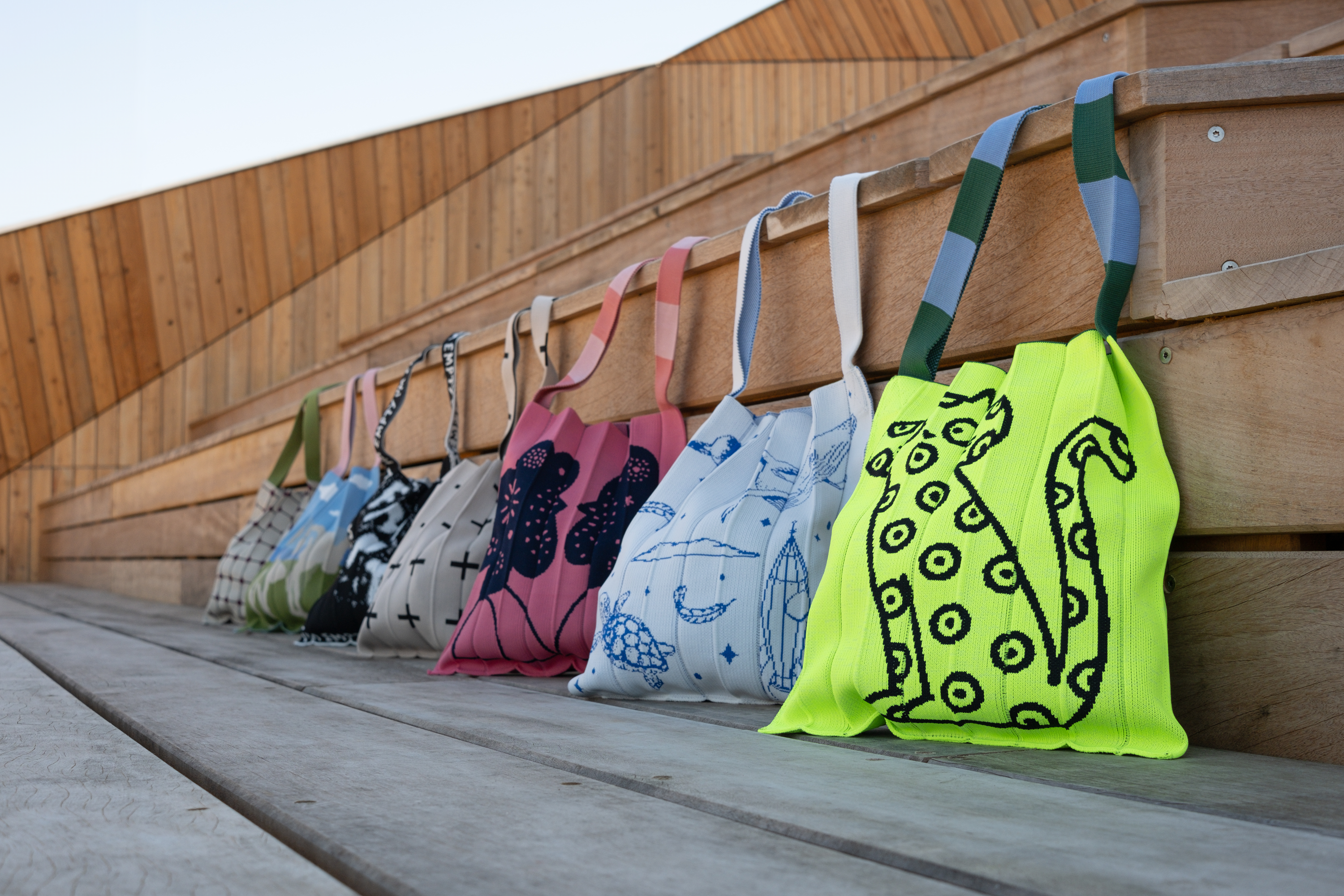 Banner featuring the Japanese handmade KNT 365 tote bags, showcasing a variety of styles and colours displayed on a wooden platform.