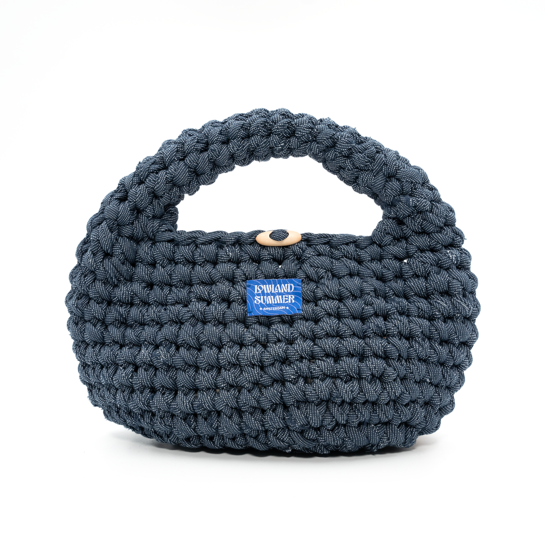 Blue woven handbag with a visible brand label on a white background