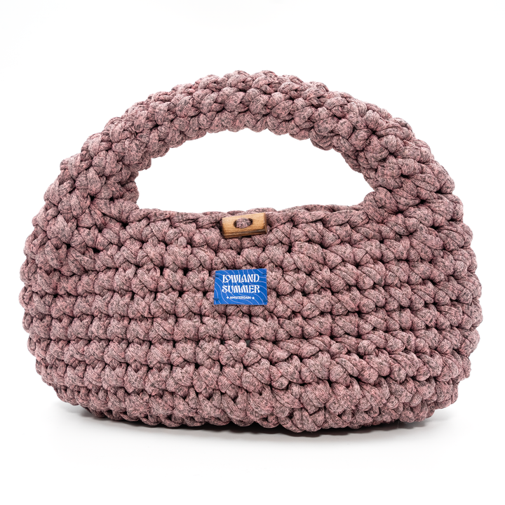 Pink knitted handbag with a visible brand label on a white background