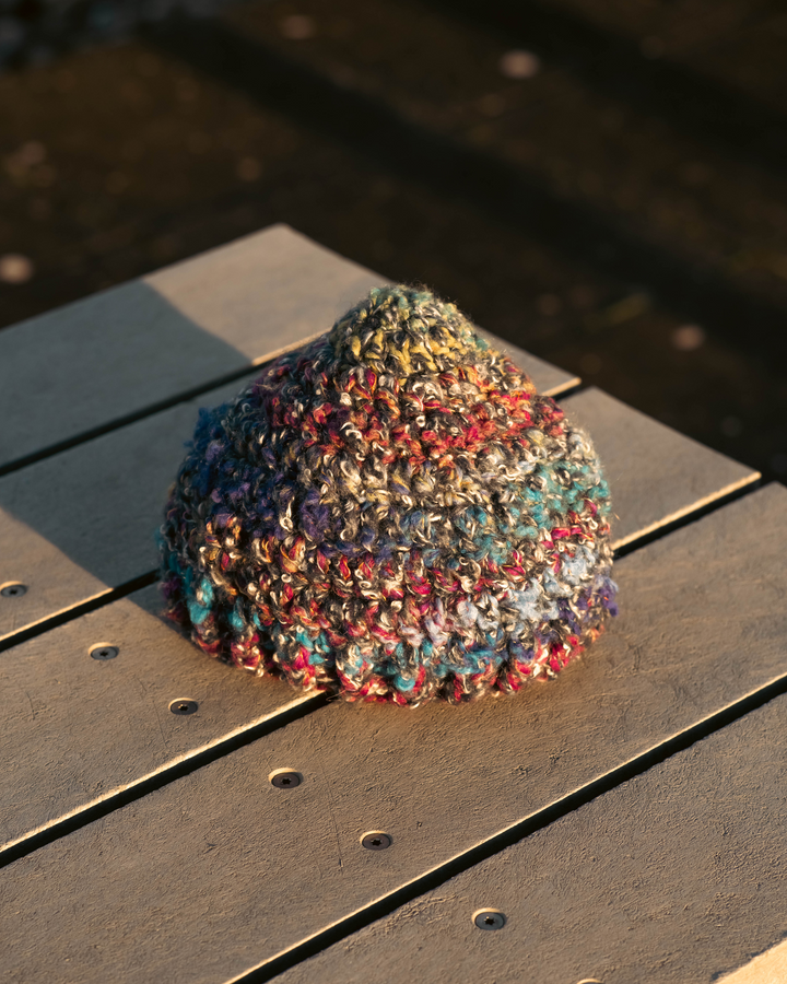 Multicolored knitted beanie on a wooden surface