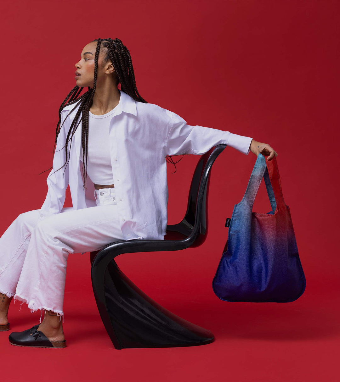 A model holding the Aurora Notabag in her hand, demonstrating its spacious size and vibrant colours.