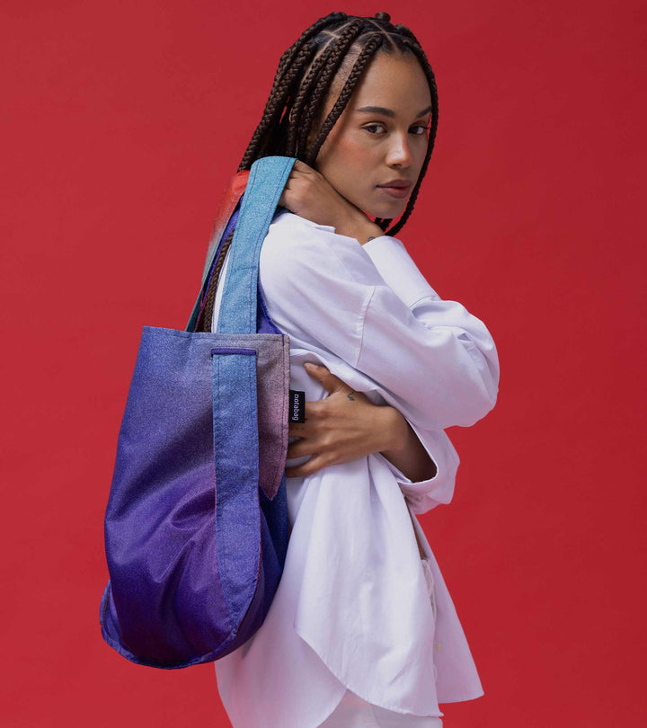 A model swinging the Aurora Notabag over her shoulder, clearly showcasing the bag's texture and dotted effect.