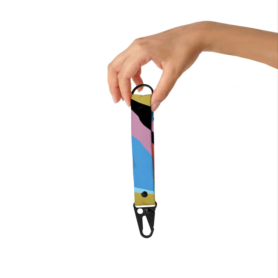Colorful lanyard with a hand holding it against a white background