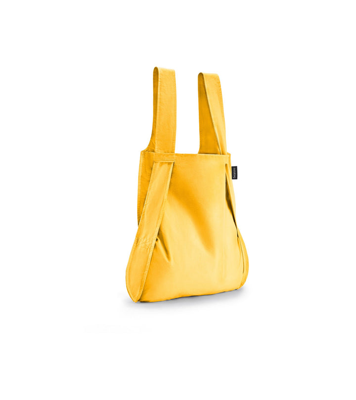 Image of a golden yellow Notabag displayed in its backpack shape, showcasing its versatility and design.