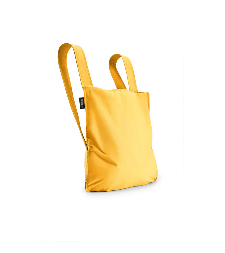 Image of a golden yellow Notabag displayed in its backpack shape, showcasing its versatility and design.