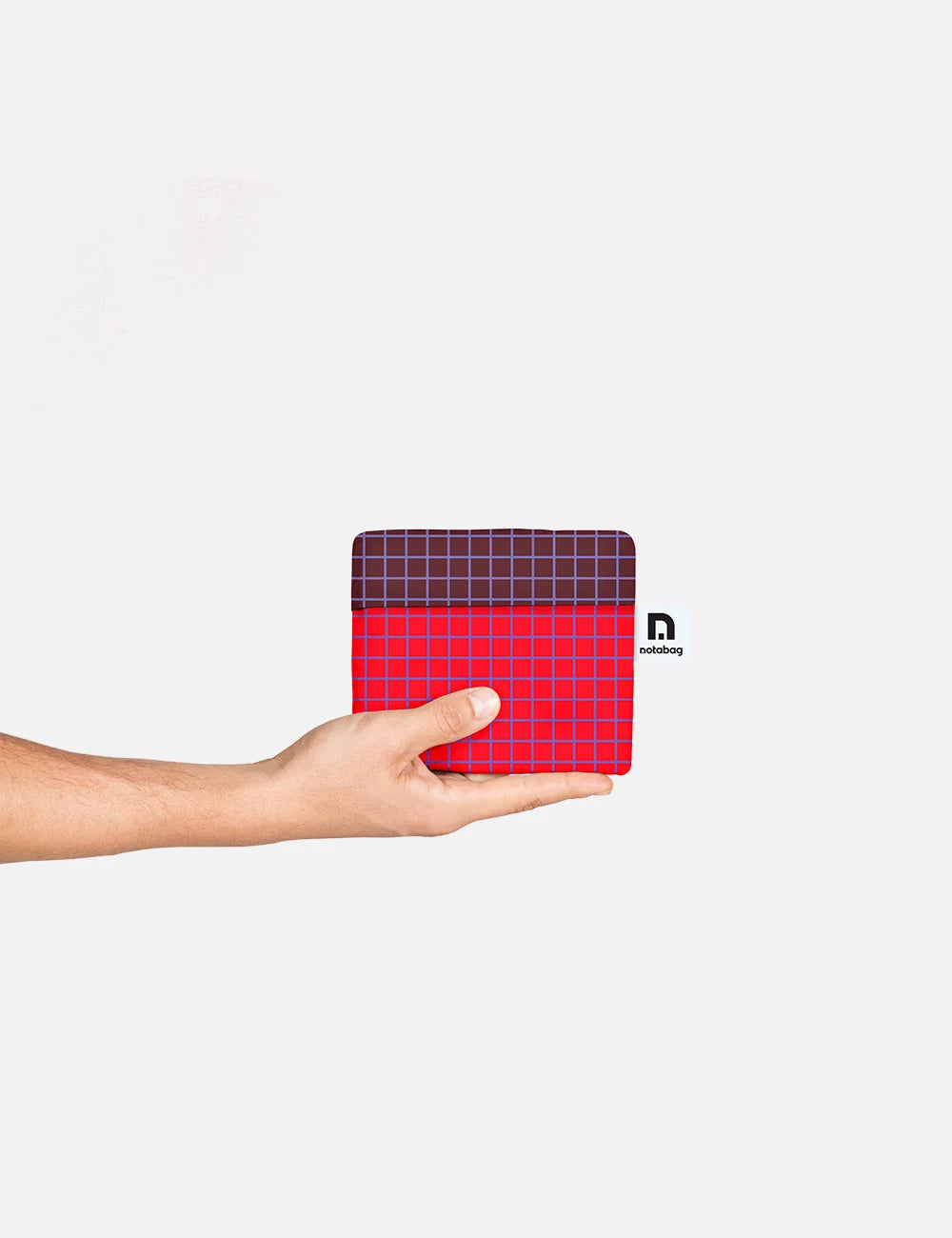 A hand holding a small square mouse pad with a red and dark purple grid pattern, shown against a plain light gray background.
