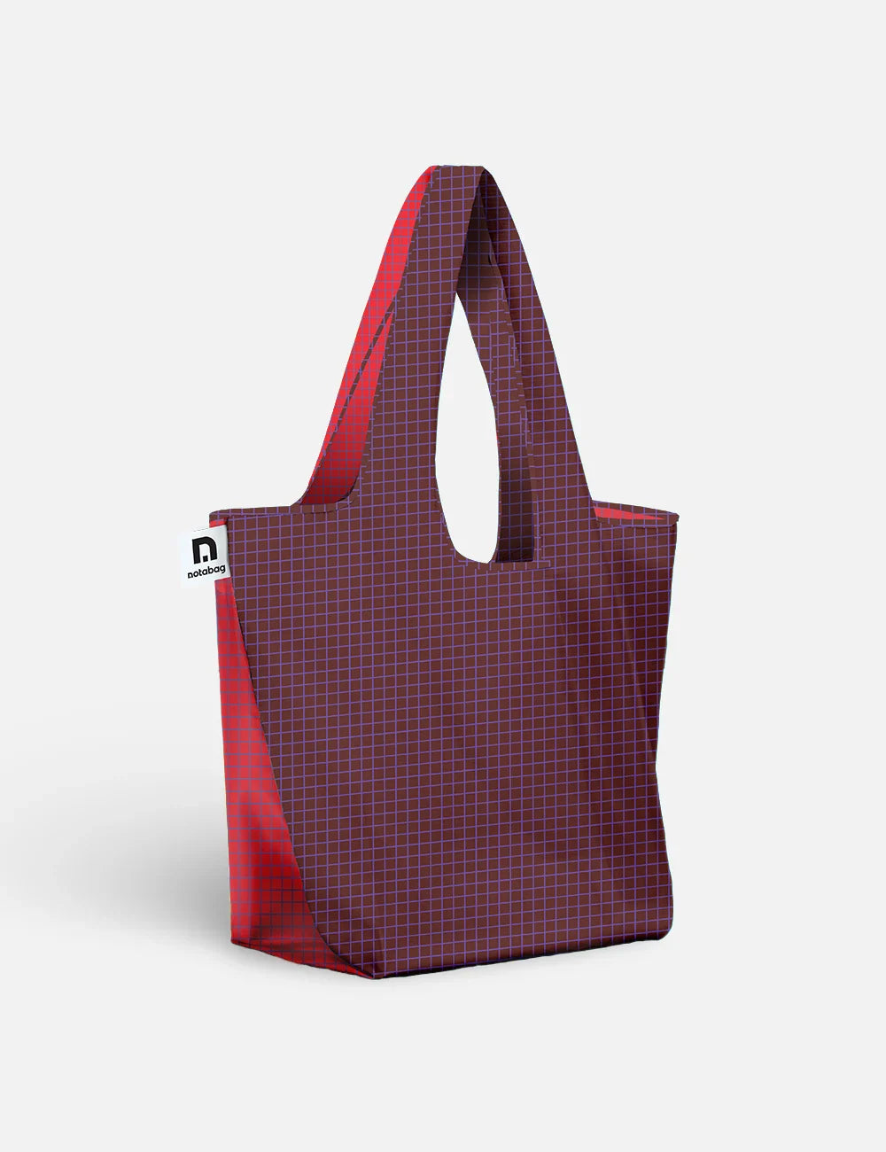 A reusable tote bag with a dark purple and red grid pattern on the front and solid red side panels and handles, shown on a light gray background.