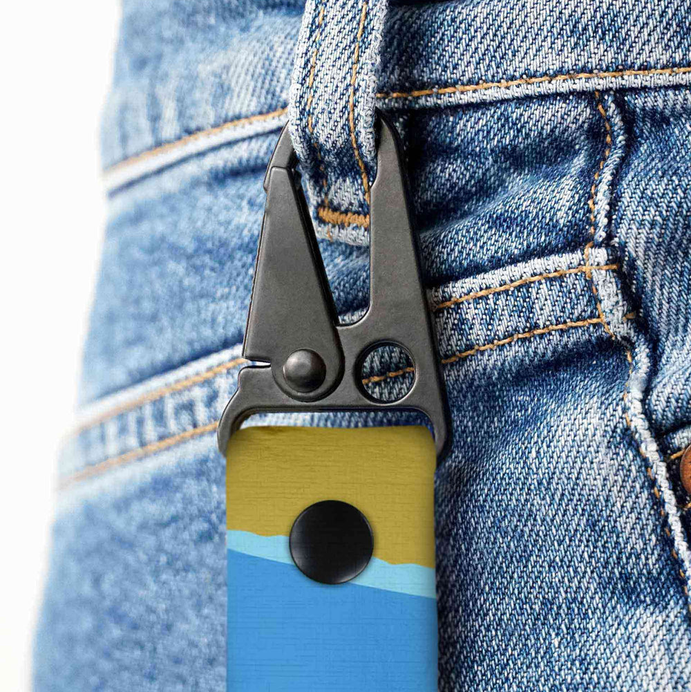 Multitool with blue and yellow design attached to a blue denim jacket.
