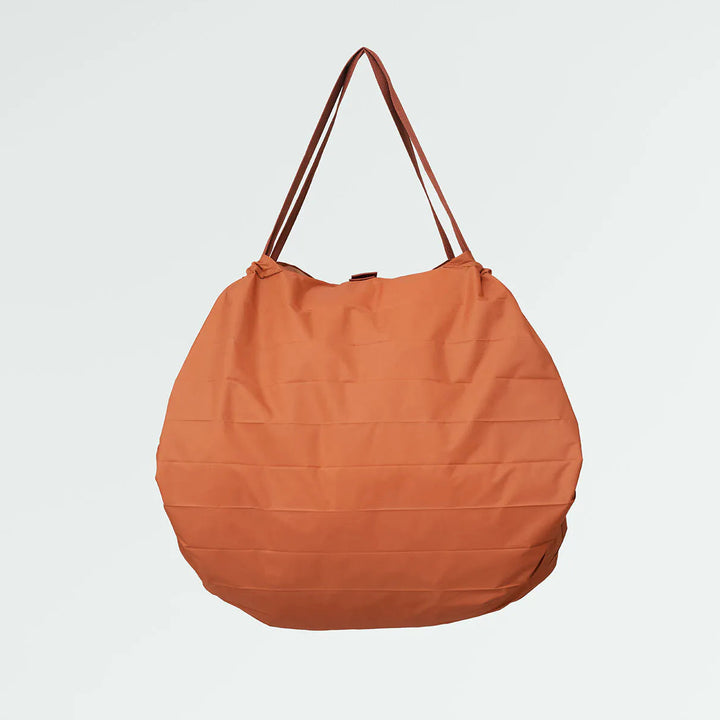Orange tote bag with brown handles on a light gray background