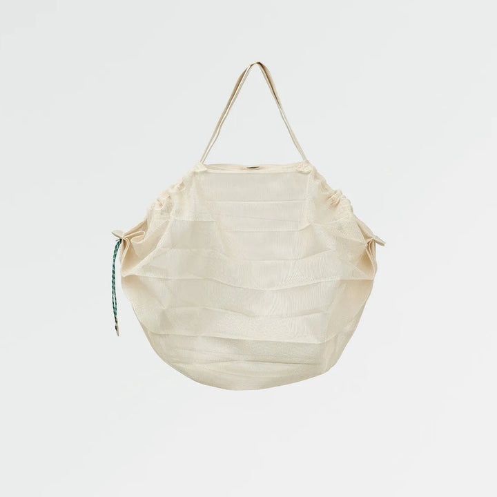 Beige woven bag with a strap on a light gray background