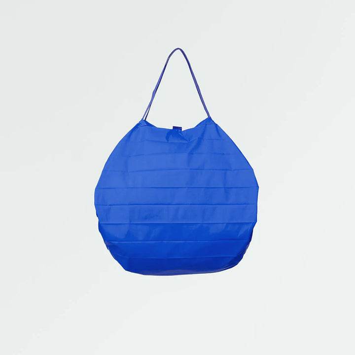 Blue Shupatto shopping bag on a light gray background