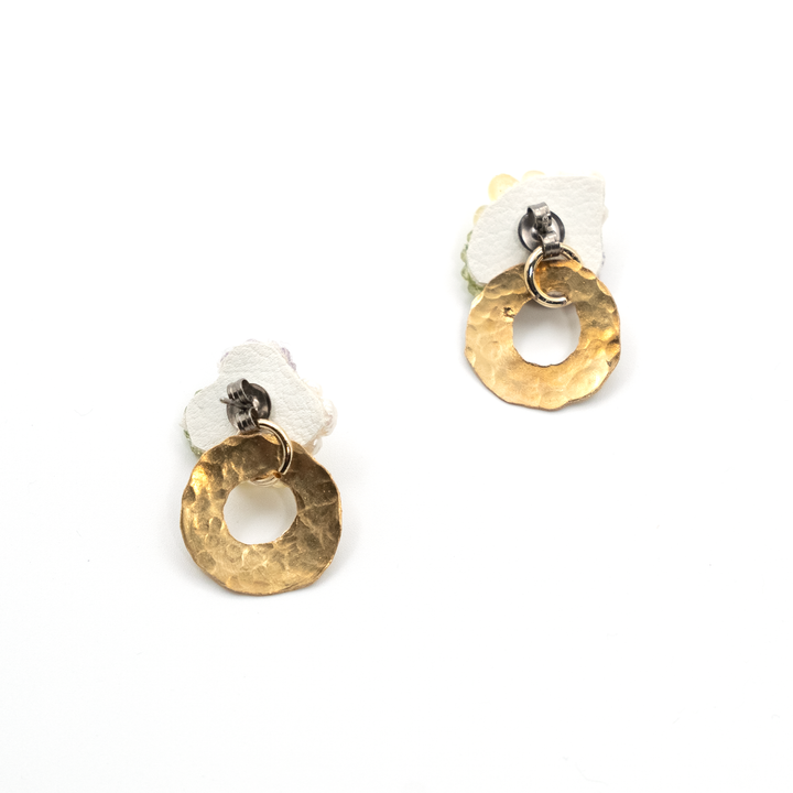 Pair of earrings with gold circular designs and white stones on a white background
