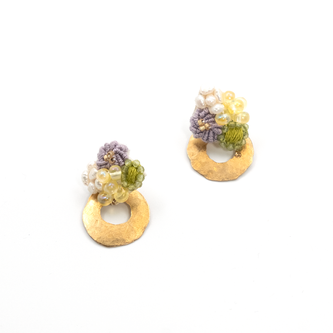 Pair of gold earrings with floral designs on a white background