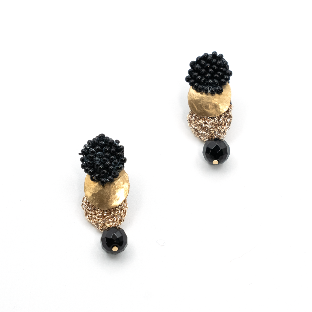 Pair of earrings with black bead accents on a white background