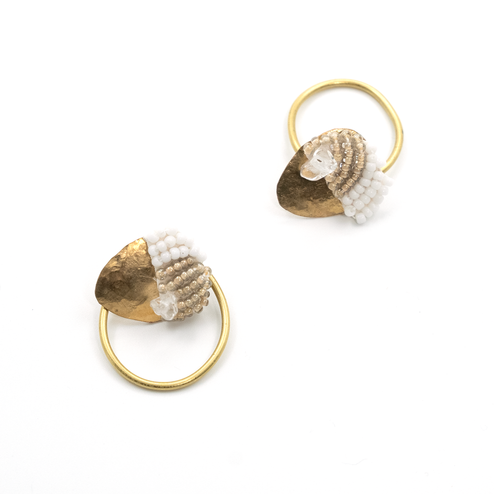 Pair of gold hoop earrings with beaded accents on a white background