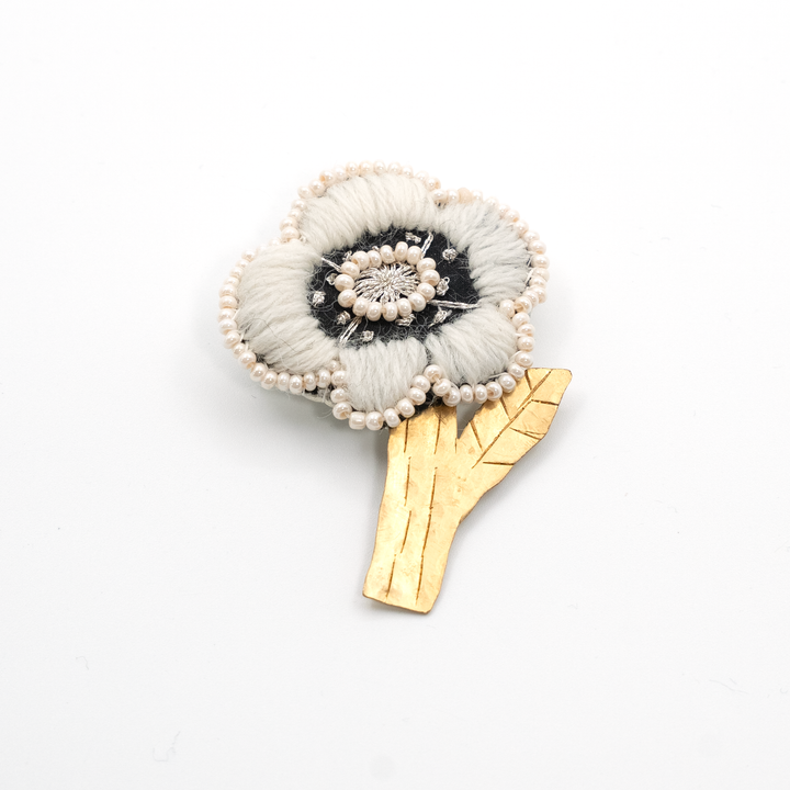 The front of the handmade white flower brooch