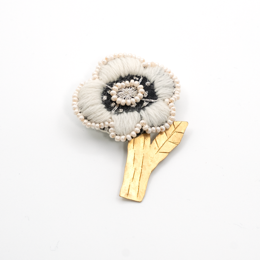 The front of the handmade white flower brooch