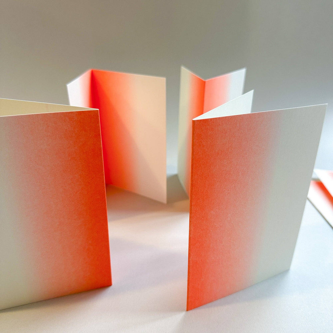 Three open books with gradient covers on a light surface