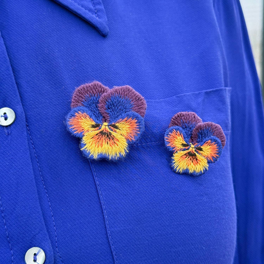 Blue fabric with embroidered pansy flowers